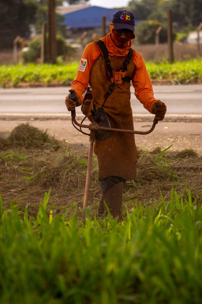 Man operating string trimmer in rural Londrina, Brazil.